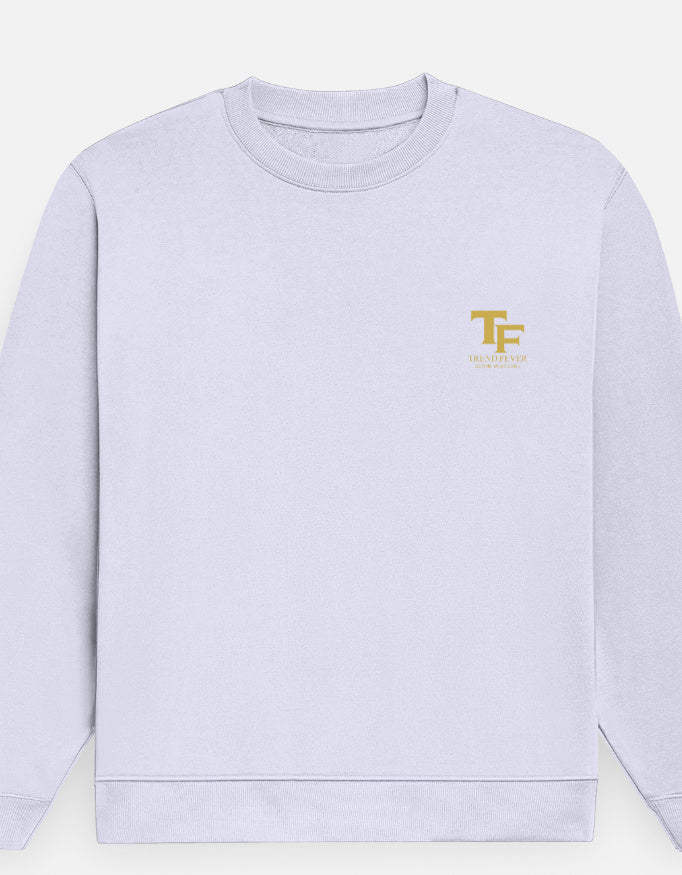 A light lavender crewneck sweatshirt with a small gold 'Trend Fever' logo on the left chest, displayed on a clean off-white background.