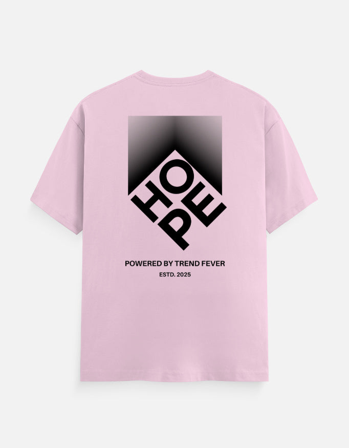 A light pink short-sleeve t-shirt shown from the back, featuring a large black graphic print of the word 'HOPE' inside a diamond shape with a gradient background. Below the graphic, the text reads 'POWERED BY TREND FEVER' and 'ESTD.