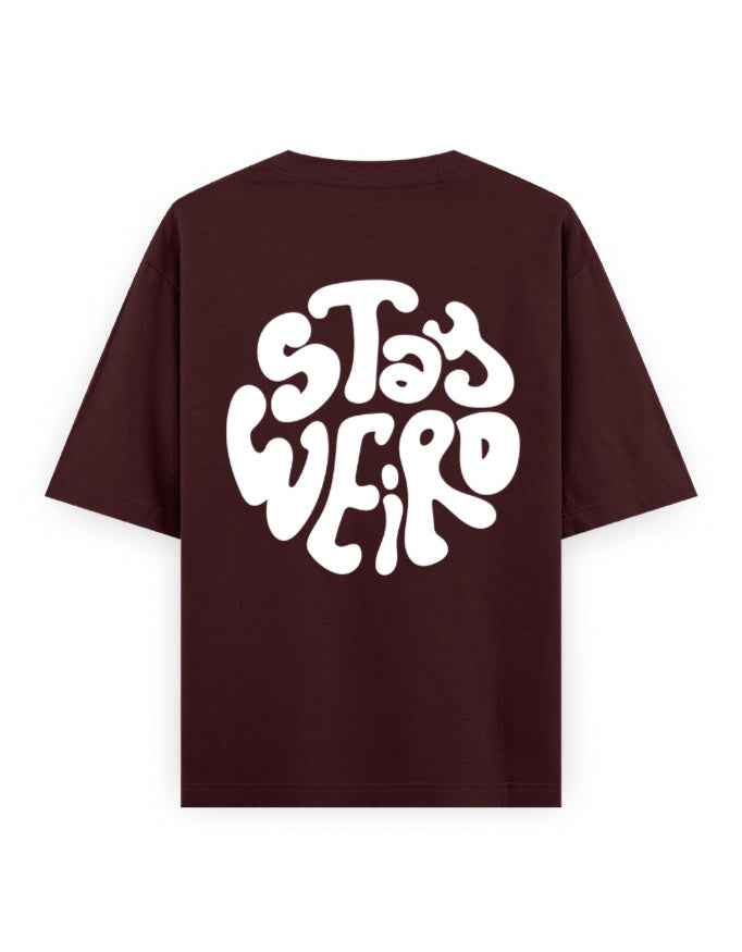 Oversized maroon streetwear t-shirt with bold white 'Stay Weird' graphic on the back