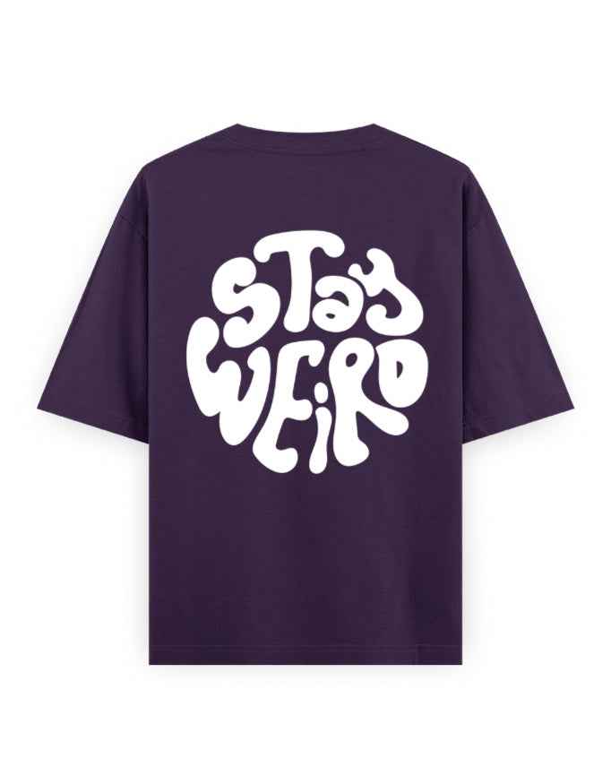 Purple oversized t-shirt with bold white 'Stay Weird' graphic on the back, streetwear fashion