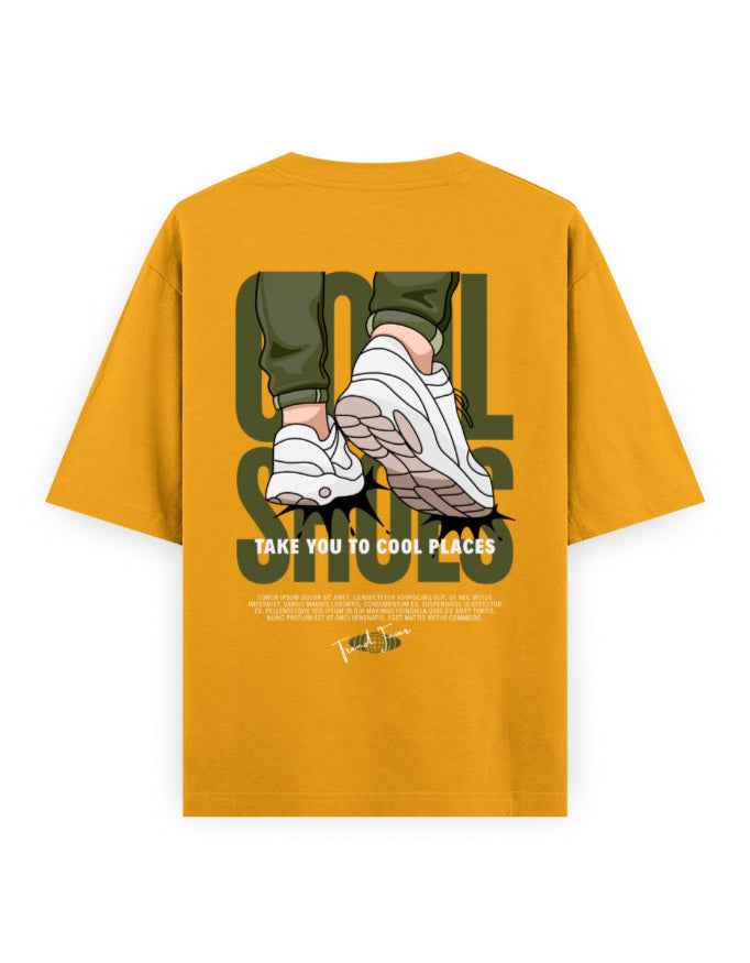 Mustard yellow oversized streetwear t-shirt with graphic of sneakers, text 'Cool Shoes Take You to Cool Places'.