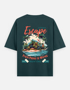 A dark teal green t-shirt shown from the back, featuring a colorful graphic print of a tropical island with palm trees, waves, and retro-style text reading 'Escape from Peaks to Waves' and 'Nature's Best 2026'.