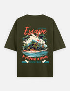 An olive green short-sleeve t-shirt with a colorful tropical beach graphic on the back. The graphic features the word 'Escape' in coral script, a tropical island with palm trees, a blue ocean, and text reading 'From Peaks to Waves' and 'Nature's Best'.