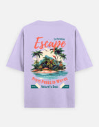 A light purple short-sleeve t-shirt shown from the back, featuring a colorful graphic print of a tropical island with palm trees and text that reads 'Escape' and 'From Peaks to Waves'.