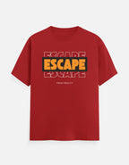 A red short-sleeve crewneck t-shirt with a graphic on the chest featuring the word 'ESCAPE' in yellow and black, layered over a faded white outline of the same word, with 'FROM REALITY' printed below in small white letters.
