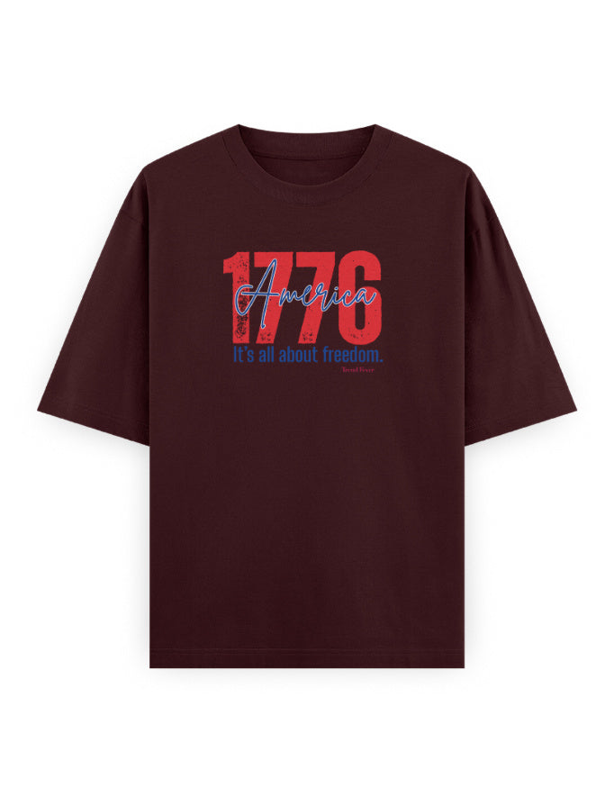 Oversized maroon streetwear t-shirt with '1776 America' bold graphic and freedom slogan.