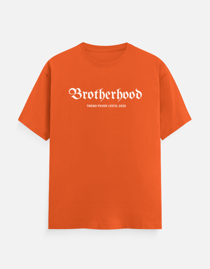 An orange short-sleeve t-shirt with 'Brotherhood' printed in a white gothic font across the chest, and smaller text underneath reading 'THING FEVER ESTD. 2020', shown on a light gray background.