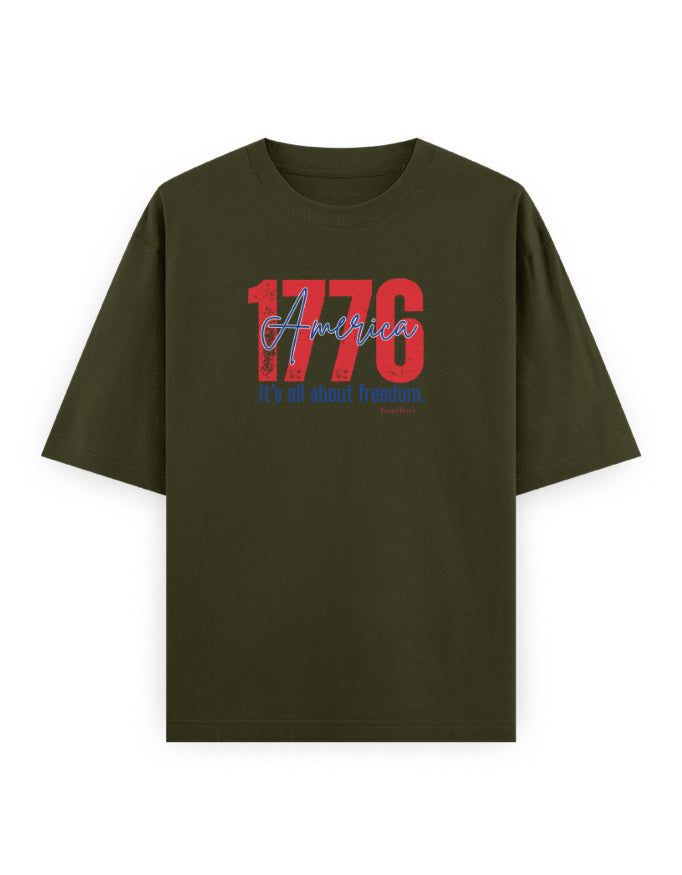 Olive green oversized t-shirt with '1776 America It's all about freedom.' graphic print.