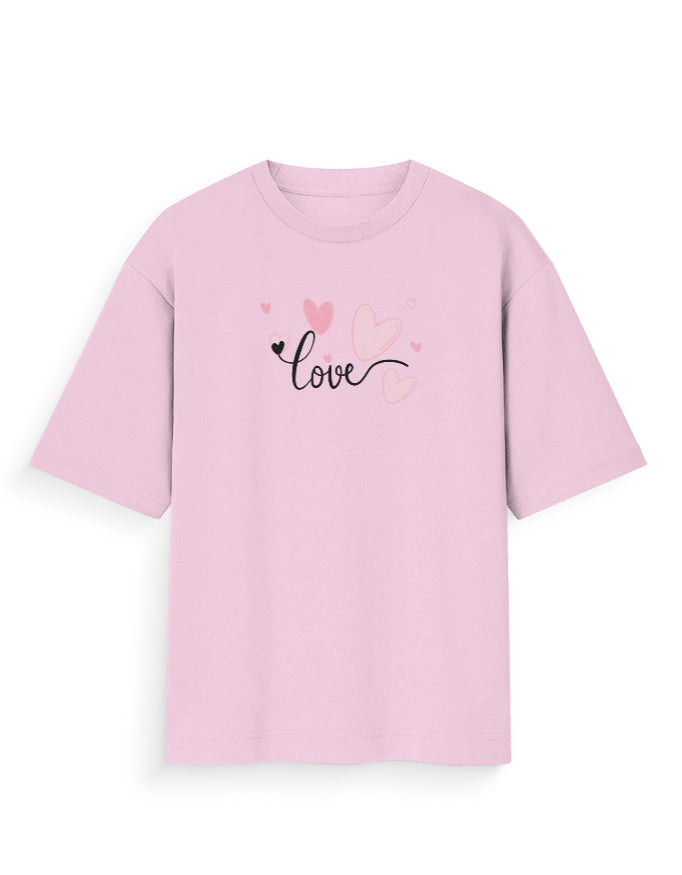 Oversized pink t-shirt with 'love' script and heart graphics, streetwear fashion.