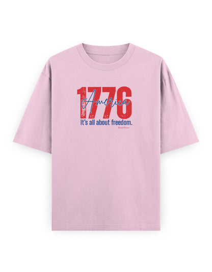 Light pink oversized t-shirt with bold red '1776 America' and 'It's all about freedom' graphic print