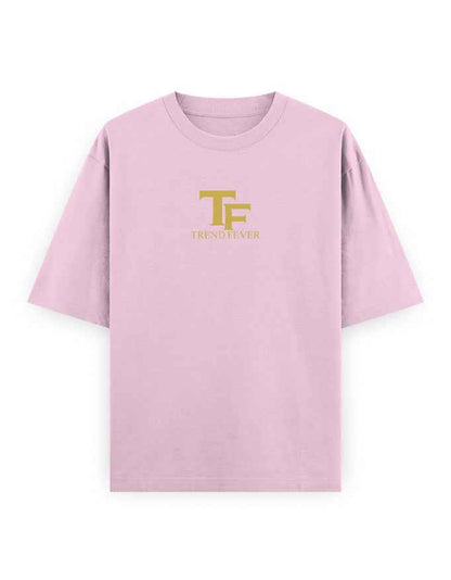 Light pink oversized t-shirt with gold TF logo and text on front, streetwear style