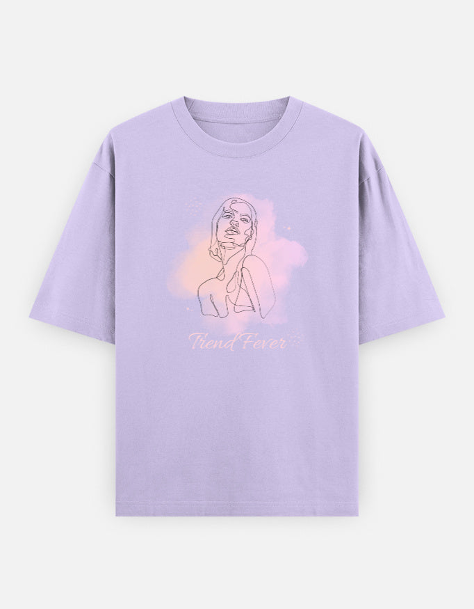 A light purple short-sleeve t-shirt with a minimalist line art graphic of a woman's face and a pastel pink watercolor splash on the chest, with the text 'Trend Fever' printed below.