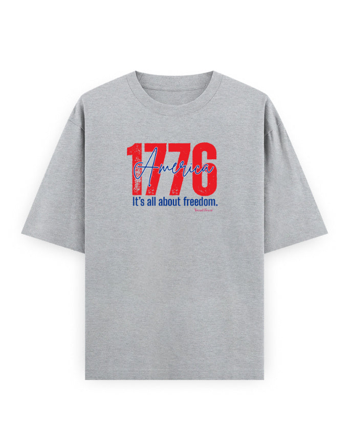 Grey oversized t-shirt with red '1776 America' and blue 'It's all about freedom' graphic print