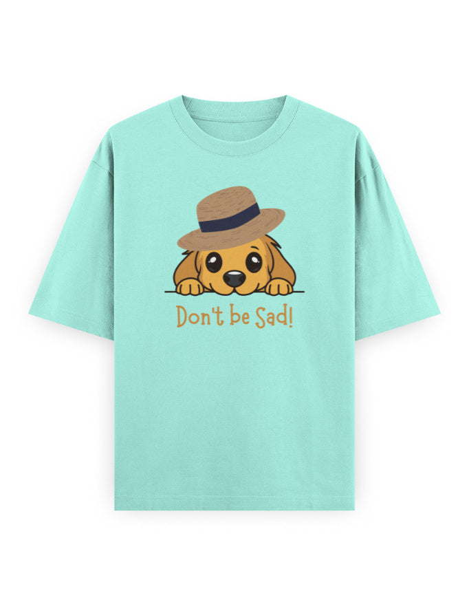 Mint green oversized t-shirt with cartoon dog in a hat and text 'Don't be Sad!' on front.