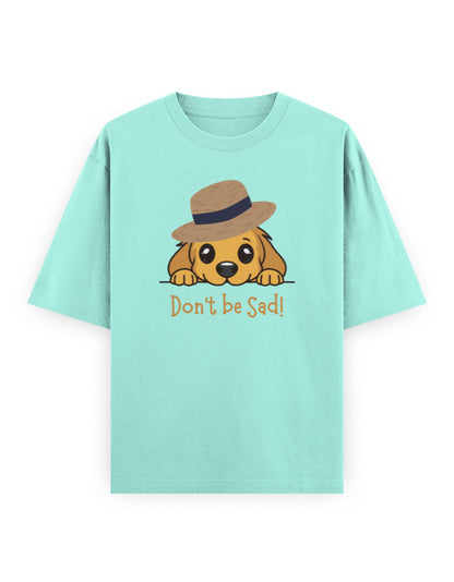 Mint green oversized t-shirt with cartoon dog in a hat and text 'Don't be Sad!' on front.