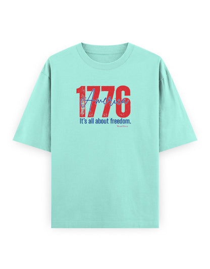 Mint green oversized t-shirt with '1776 America It's all about freedom' slogan graphic print.