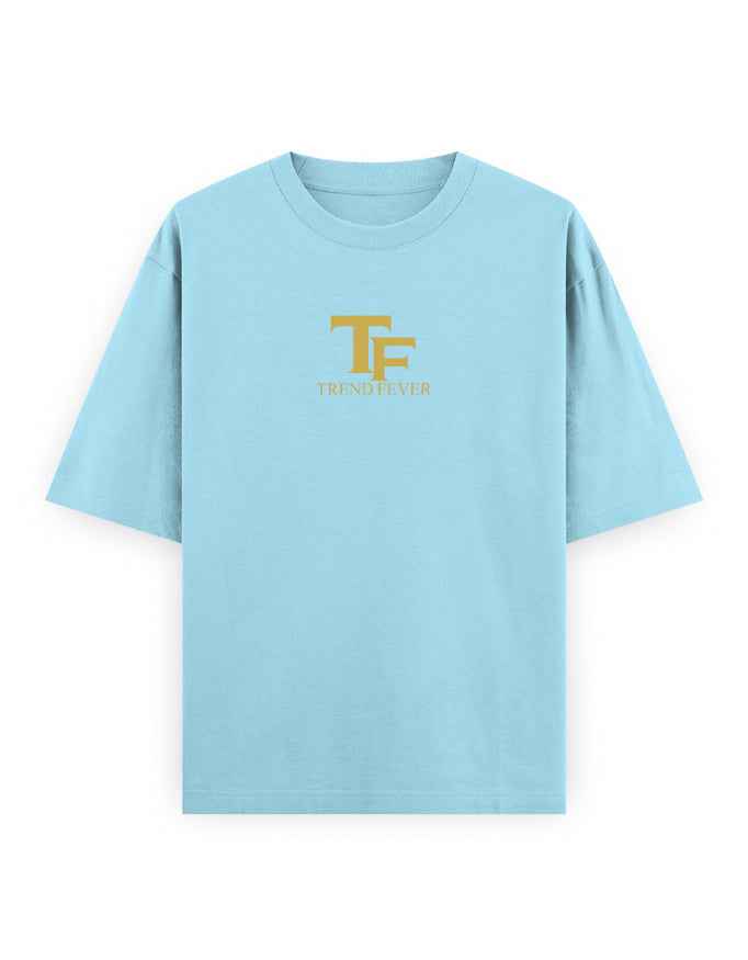 Light blue oversized t-shirt with gold TF logo and Trend Fever text on chest, streetwear style
