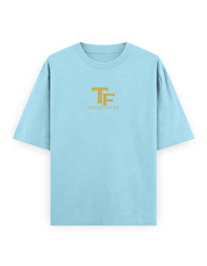 Light blue oversized t-shirt with gold TF logo and Trend Fever text on chest, streetwear style