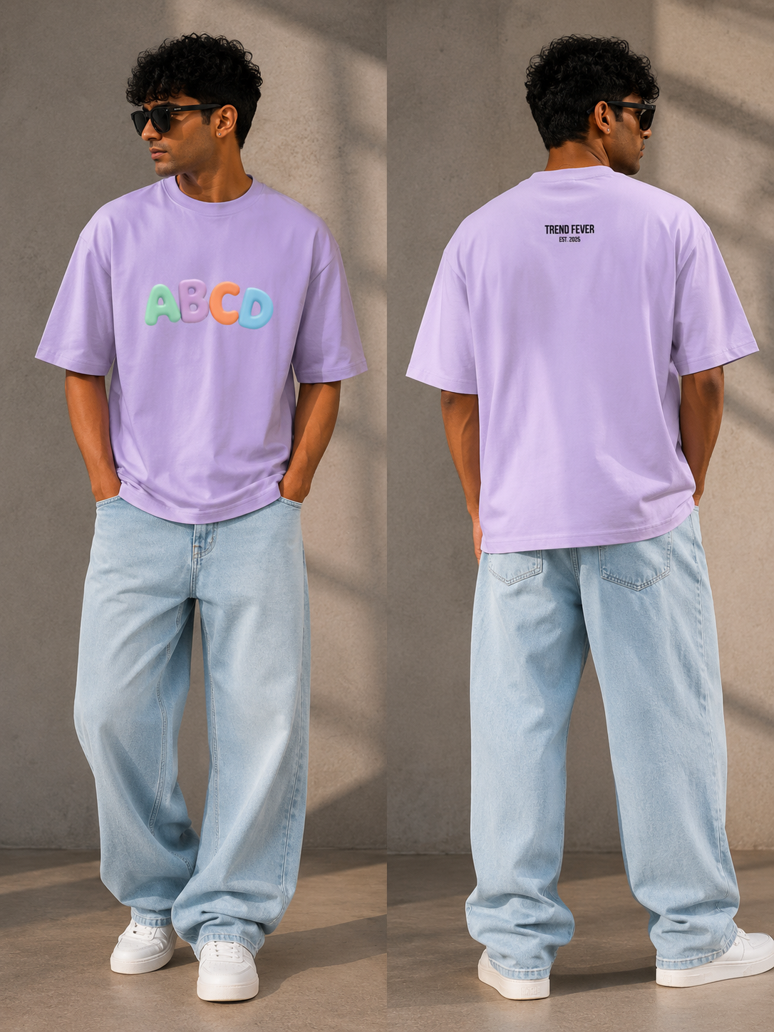 A man modeling a light purple t-shirt from both front and back views, paired with light blue jeans and white sneakers against a textured concrete wall.