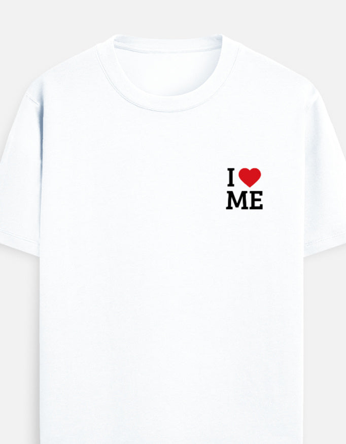 A white short-sleeve crewneck t-shirt featuring a small graphic on the left chest that reads 'I' followed by a red heart and ' I LOVE ME' in black block letters by TREND FEVER
