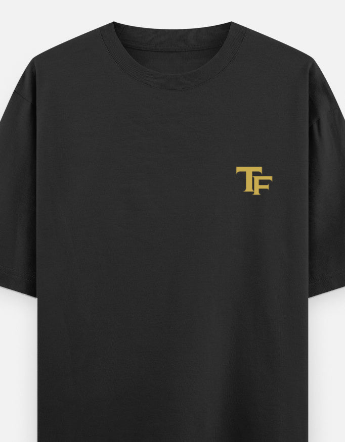 A black short-sleeve crewneck t-shirt with a small gold 'Trend Fever' logo printed on the left chest, shown against a plain light gray background.