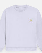 A light lavender crewneck sweatshirt with a small gold 'Trend Fever' logo on the left chest, displayed on a clean off-white background.