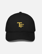A black baseball cap with a gold embroidered 'TF - Trend Fever' logo on the front, displayed against a light gray background.