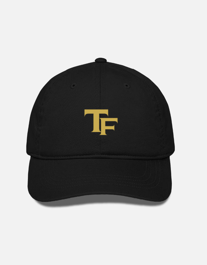 A black baseball cap with a gold embroidered 'TF - Trend Fever' logo on the front, displayed against a light gray background.