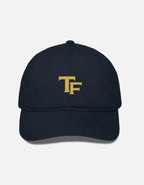 A navy blue baseball cap with a gold embroidered 'TF- Trend Fever' logo on the front, displayed against a light gray background.