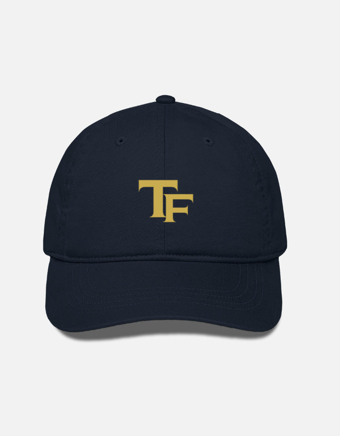 A navy blue baseball cap with a gold embroidered 'TF- Trend Fever' logo on the front, displayed against a light gray background.